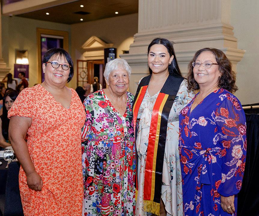 Graduating student with indigenous sash and family