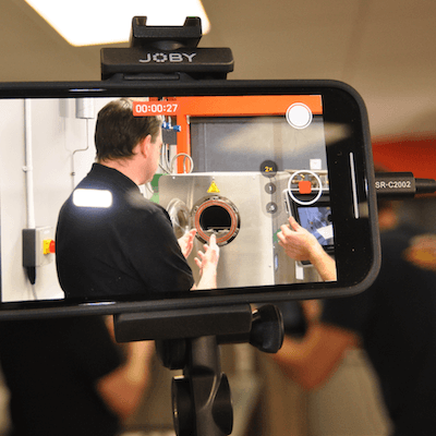 An Additive-X team member demonstrating how to use a 3D printer.