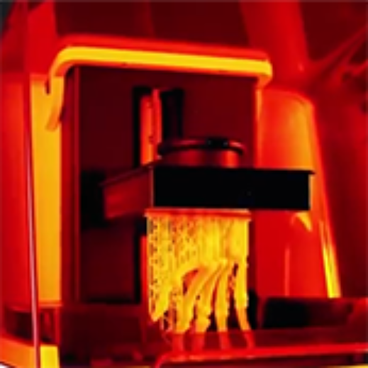 A resin 3D printer in action with red back lighting.