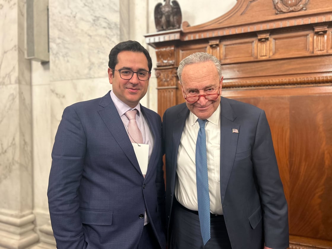 AI2 CEO Ali Farhadi poses with Senator Chuck Schumer.