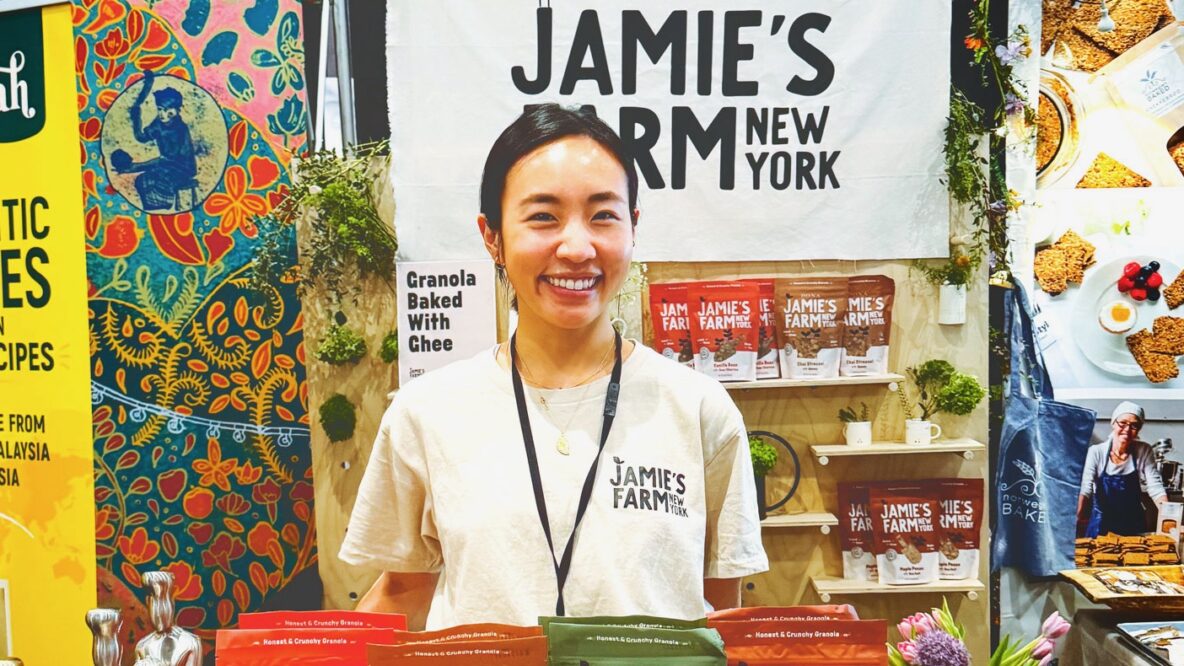 Jamie Kim smiles with a variety of her granola flavors