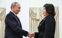 4日、モスクワのクレムリンで握手するロシアのプーチン大統領（左）と北朝鮮の崔善姫外相＝タス・共同