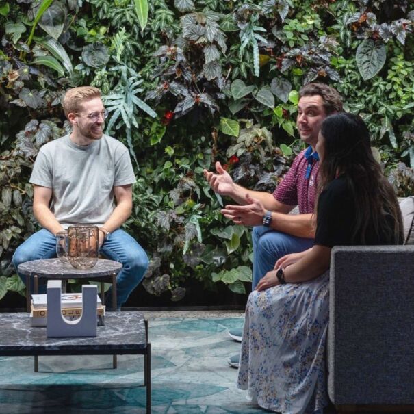 Employees engaged in discussion amidst a backdrop of plants