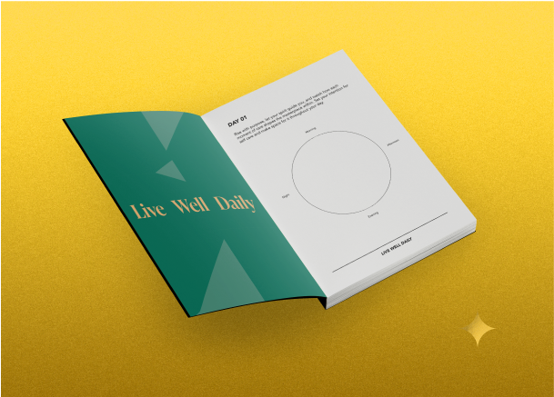 An open journal with a cover titled 'Live Well Daily,' placed on a gold background. The visible page shows a simple circular diagram with space to write notes for a daily wellness routine.