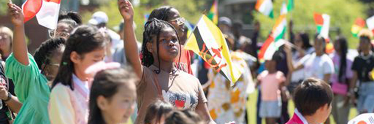 Participants walk in the Parade of Flags at the 2023 Global Community Day Festival.