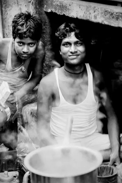 Men working at a chai stand and a steamy pot