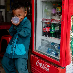 Boy taking aim with a plastic bottle