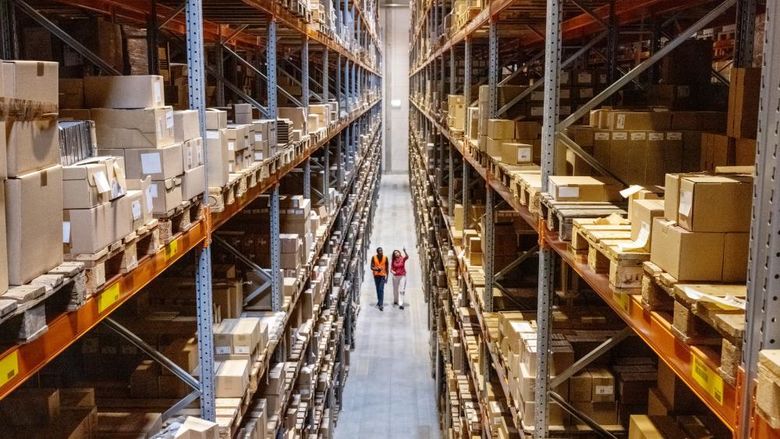 Two people walking through a warehouse