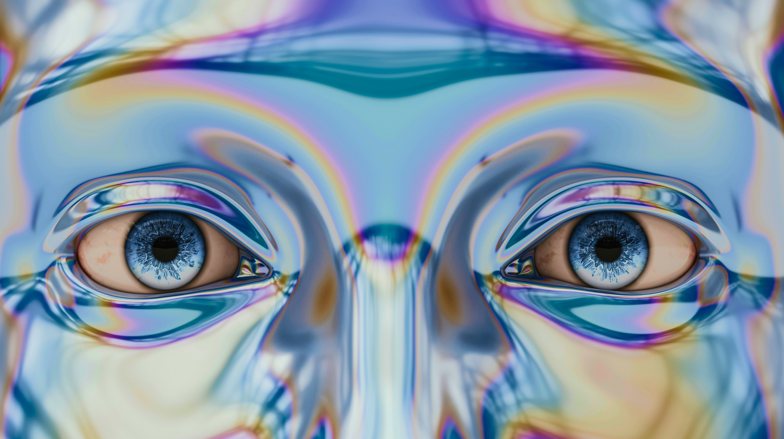 Close-up of a multicolored, reflective surface depicting two human-like eyes with iridescent hues surrounding them.