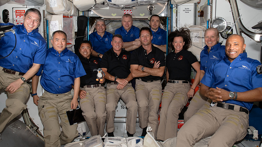 The 11-member crew aboard the station is actually a combination of three different crews: the Soyuz MS-18 crew in the back row, the SpaceX Crew-2 in the middle row, and the four SpaceX Crew-1 astronauts in the far left and right corners.