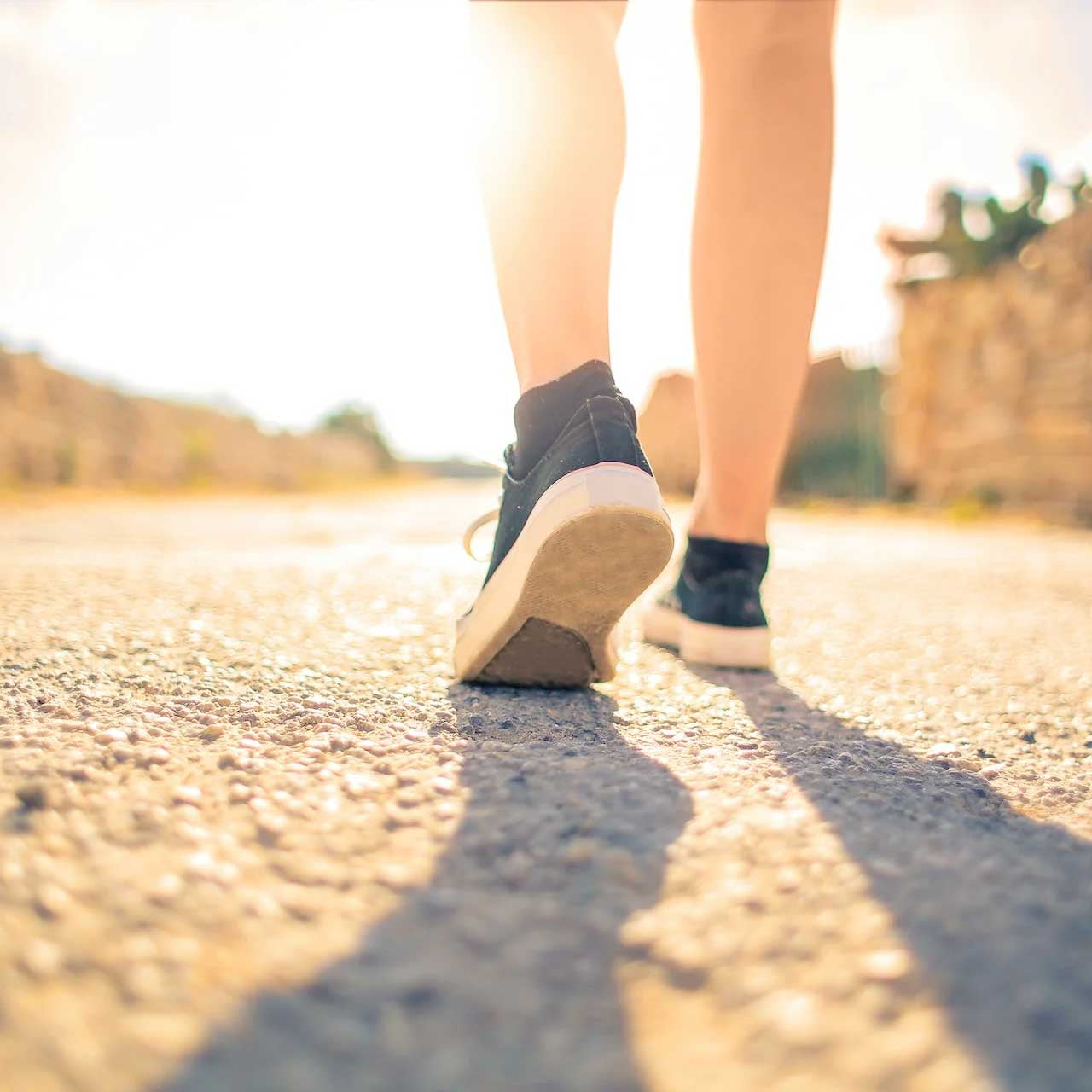 travel adventure awaits - person on a stone path wearing sneakers on a sunny day