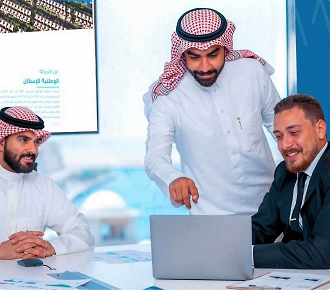 A group of men looking at a computer