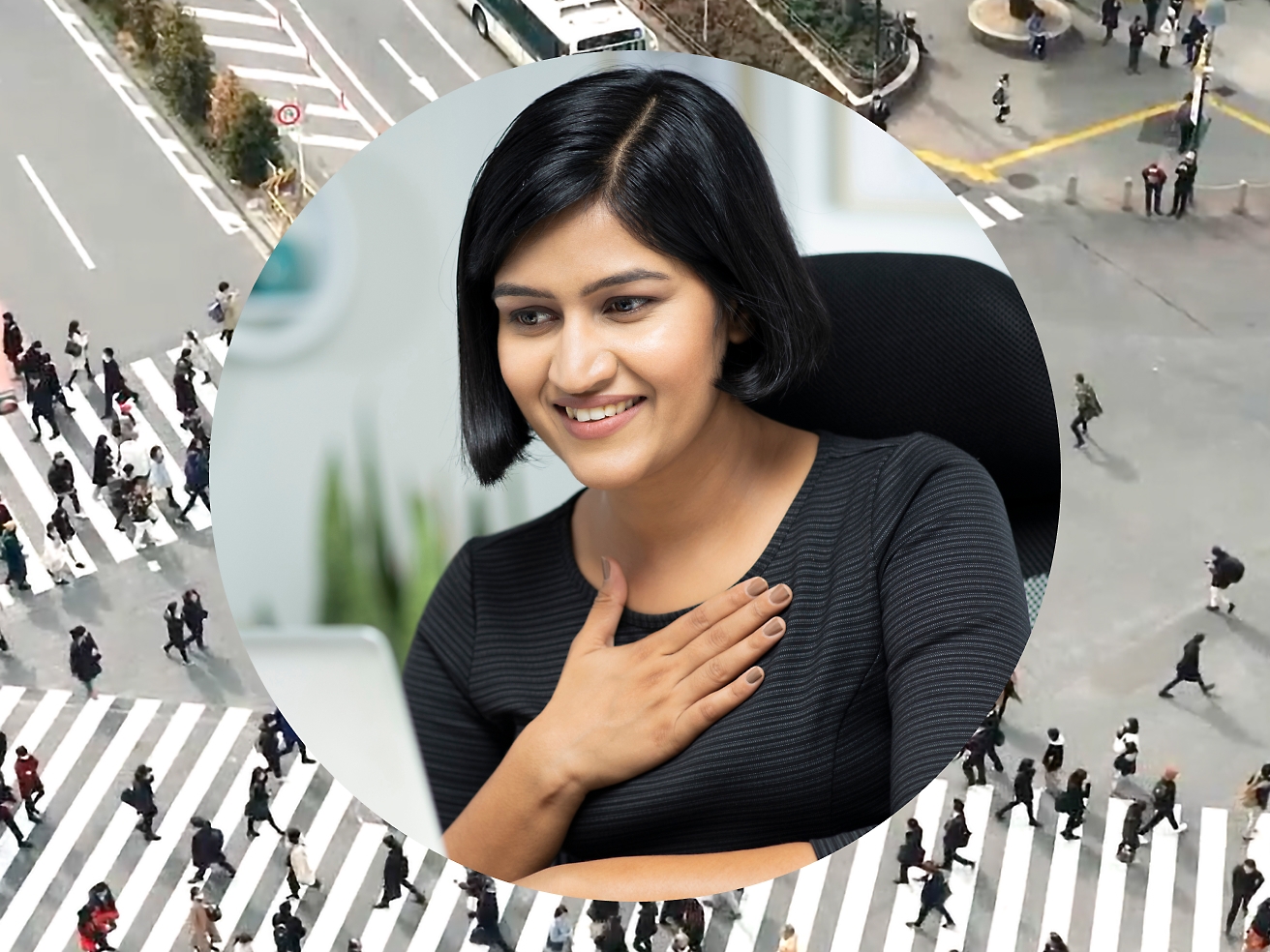 A woman holding her hand against her chest while working on her laptop, background image is set as road intersection with people passing by