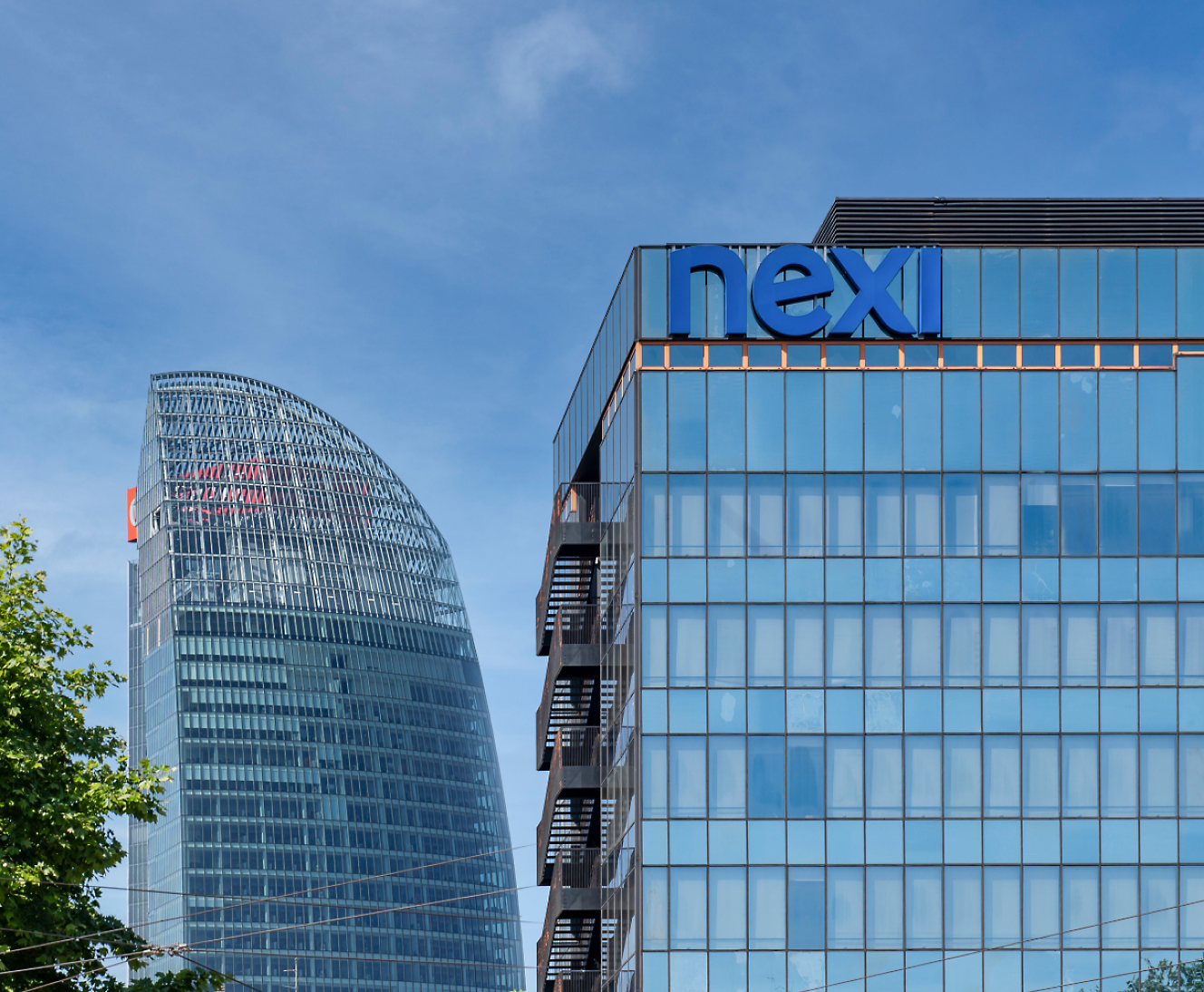 Modern office buildings with glass facades against a blue sky.