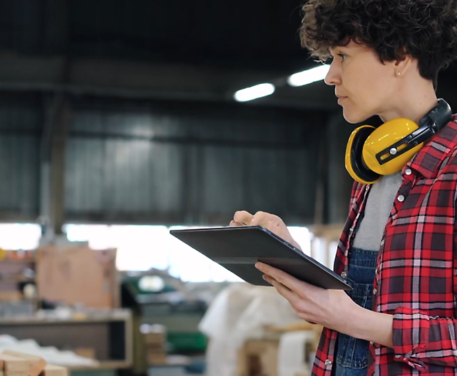 A person wearing headphones and holding a tablet