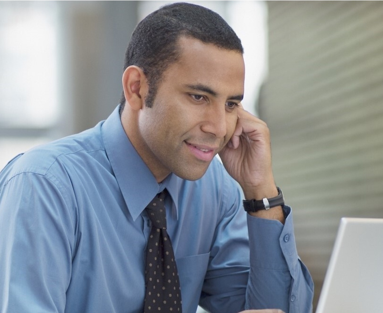 A person sitting in an office and working on his laptop