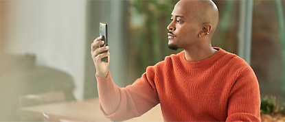 A man is taking a picture on his cell phone.