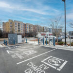 An EV charging location with multifamily buildings in the background.