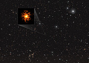 The image shows a colourful field of stars and galaxies. One faint star is highlighted with a white box, and connected with a white line to a larger overlaid image, showing a blurry, orange blob shape.