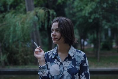 Portrait of young woman smoking cigarette