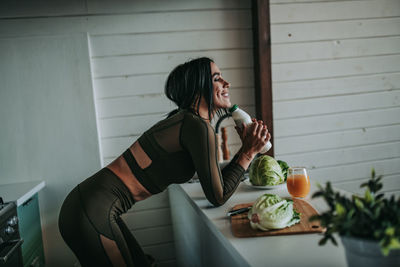 Woman looking away while sitting on table at home