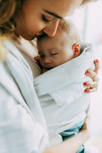 Mother carrying newborn son at home