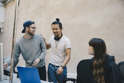 Happy male and female computer programmers in office