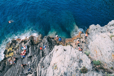 High angle view of people on rocks by sea