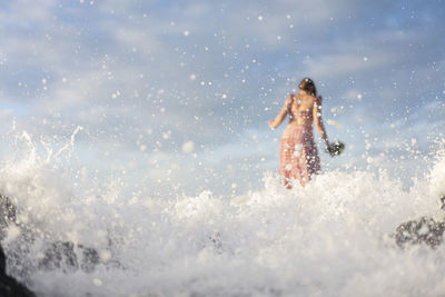 Full length of woman splashing water