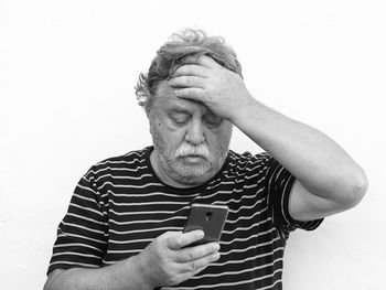 Midsection of man using smart phone against white background