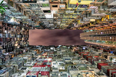 Directly below shot of buildings against sky in city