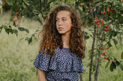 Portrait of teenage girl standing against plants