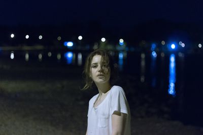 Portrait of smiling woman standing on illuminated land