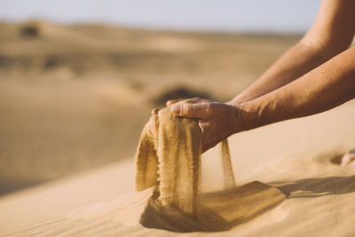 Close-up of hands with sand