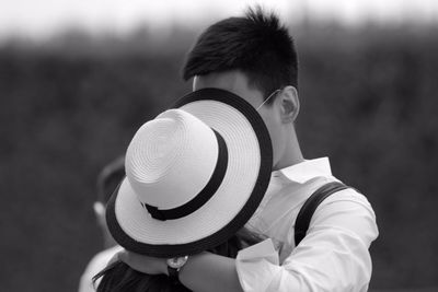 Woman in hat kissing boyfriend