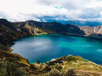 Scenic view of lake by mountains against sky