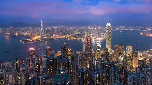 Aerial view of illuminated city and buildings against sky