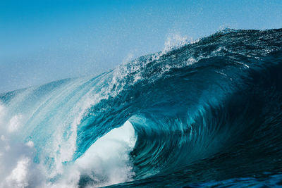 Waves splashing against blue sky