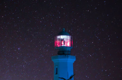 Low angle view of lighthouse against sky at night