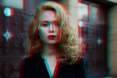 Portrait of young woman against wall