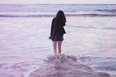 Rear view of woman standing on beach