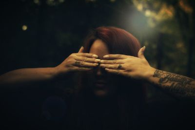 Woman closing her eyes in forest