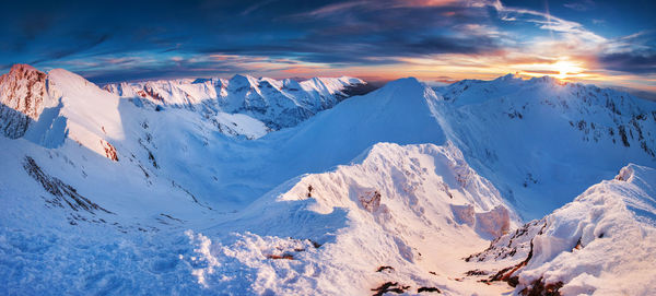 Scenic view of snowcapped mountains against sky during sunset