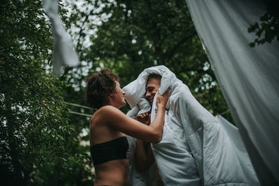 Rear view of couple standing against trees