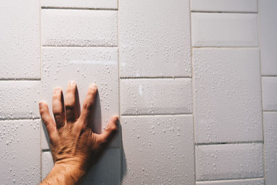 Close-up of hand on wet wall