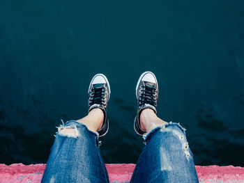 Low section of person sitting over water