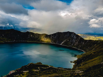 Scenic view of lake by mountains against sky