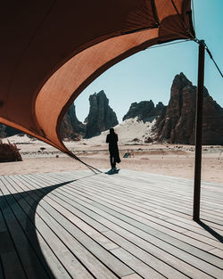 Rear view of man walking on footpath