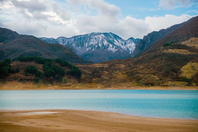 Scenic view of lake and mountains against sky