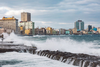 Scenic view of sea by buildings against sky